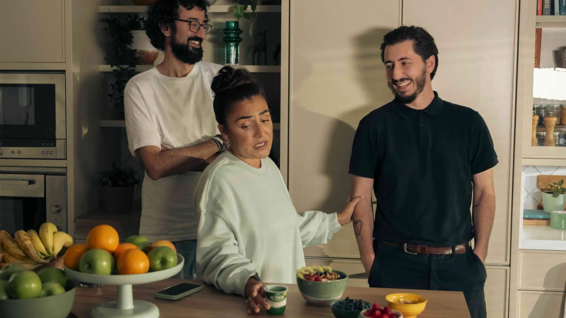 Anuncio de Activia: la protagonista sostiene un Activia en una escena de cocina con dos actores