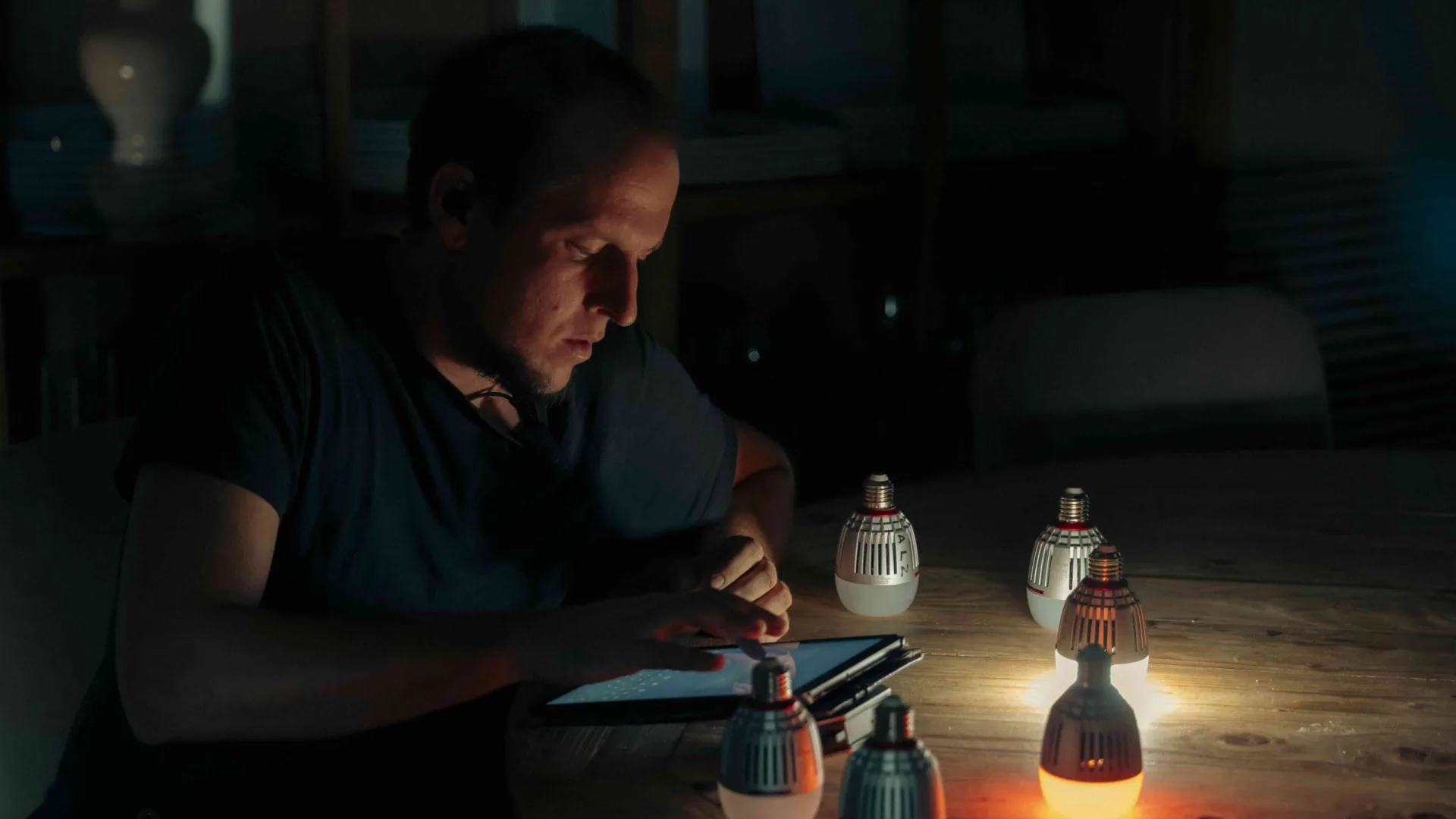 Rodaje de Activia: un técnico controla pequeñas bombillas LED desde una tableta sobre una mesa de madera