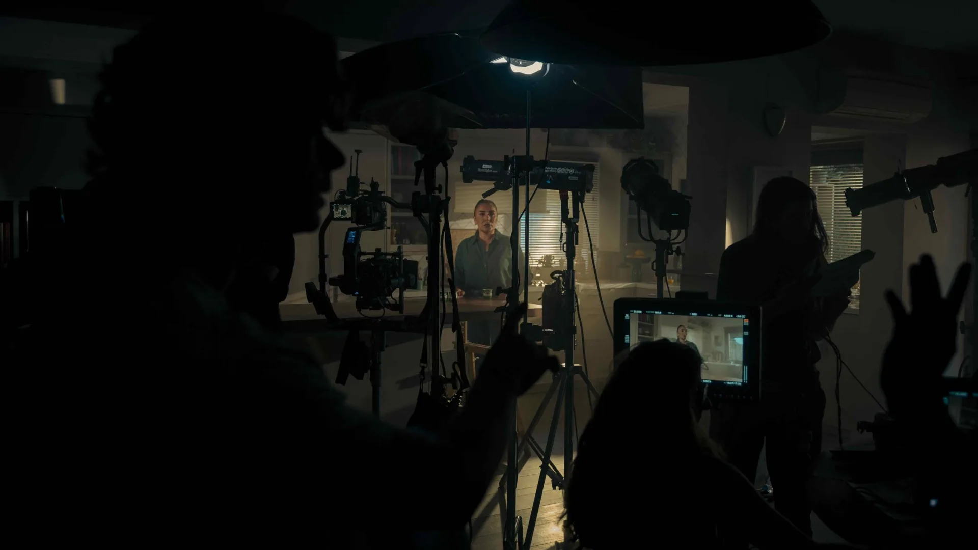 Rodaje de Activia: la actriz en el set de cocina iluminado, entre siluetas del equipo y un monitor