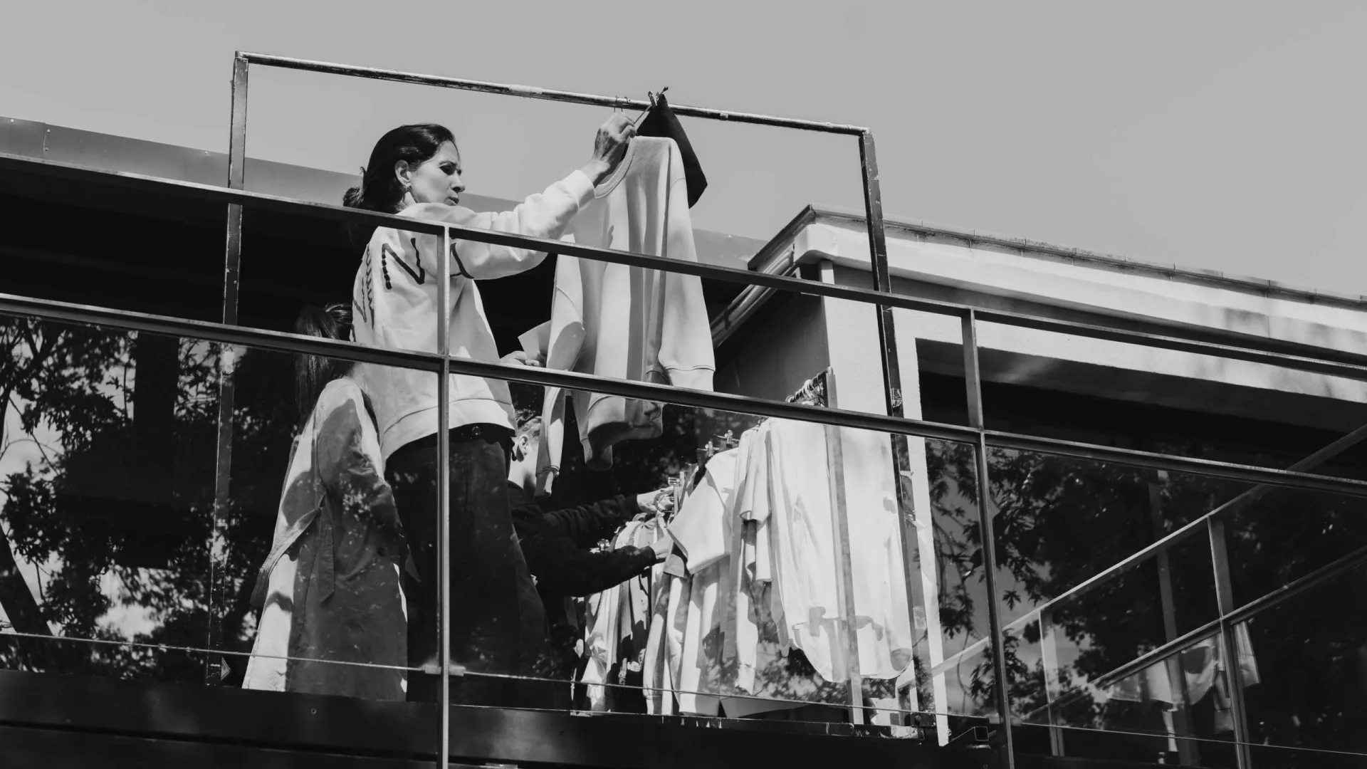 Rodaje de Activia: vestuario cuelga la ropa en un burro en una terraza, en blanco y negro