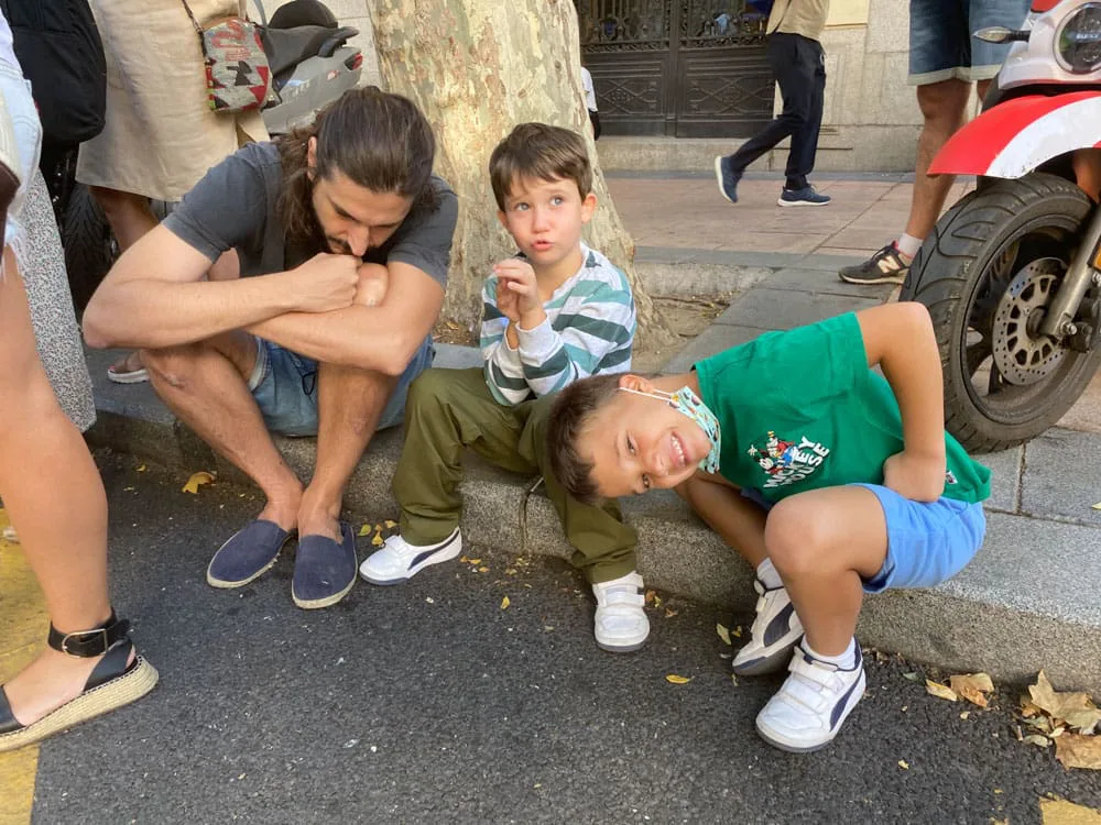 Alsa, making of: un miembro del equipo y dos niños esperan en el bordillo entre tomas