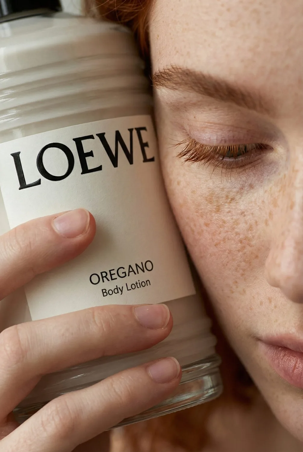 Mujer con una loción corporal Loewe Oregano junto a la cara, de un trabajo de Arminas Valunas