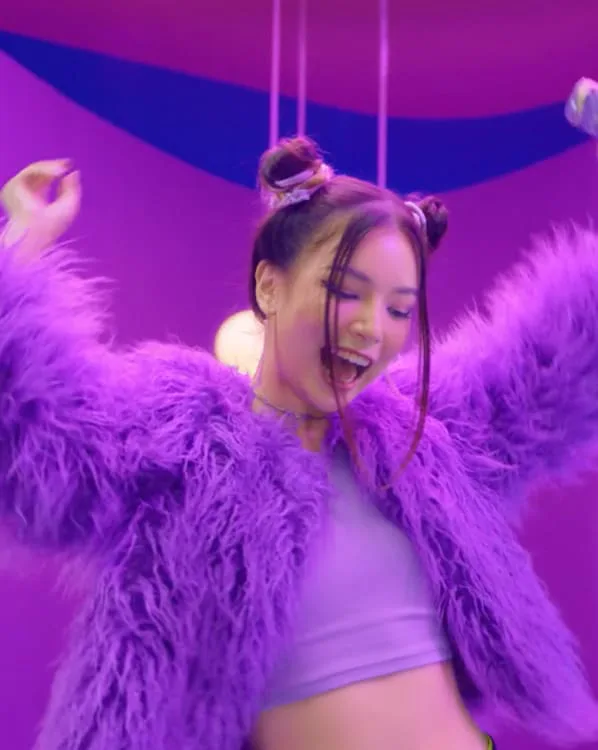 Bailarina con chaqueta de pelo morado en un set morado, de un anuncio de Bonamaze