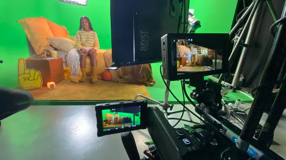 Producción virtual de ColaCao: una niña en un sofá amarillo sobre croma, vista a través de los monitores