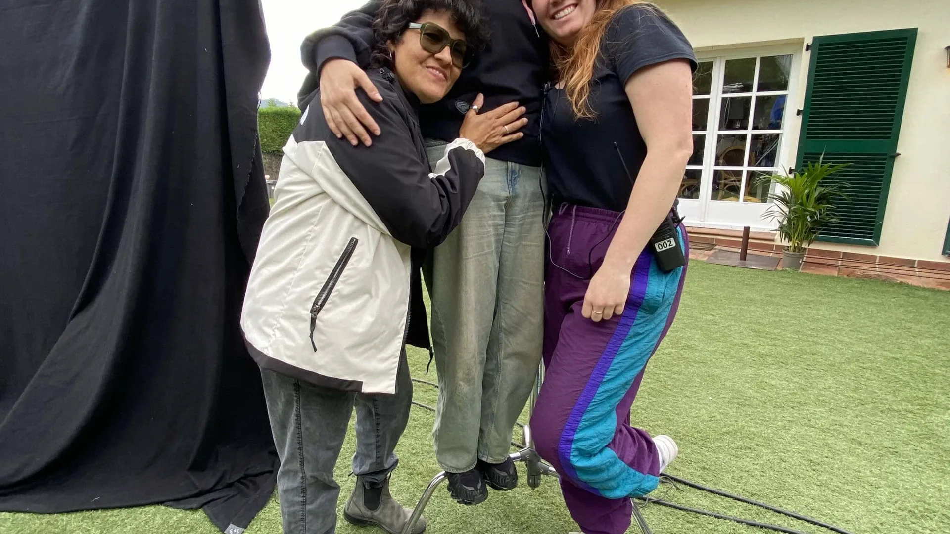 Making of de ColaCao Minions: tres miembros del equipo abrazados en el set del jardín
