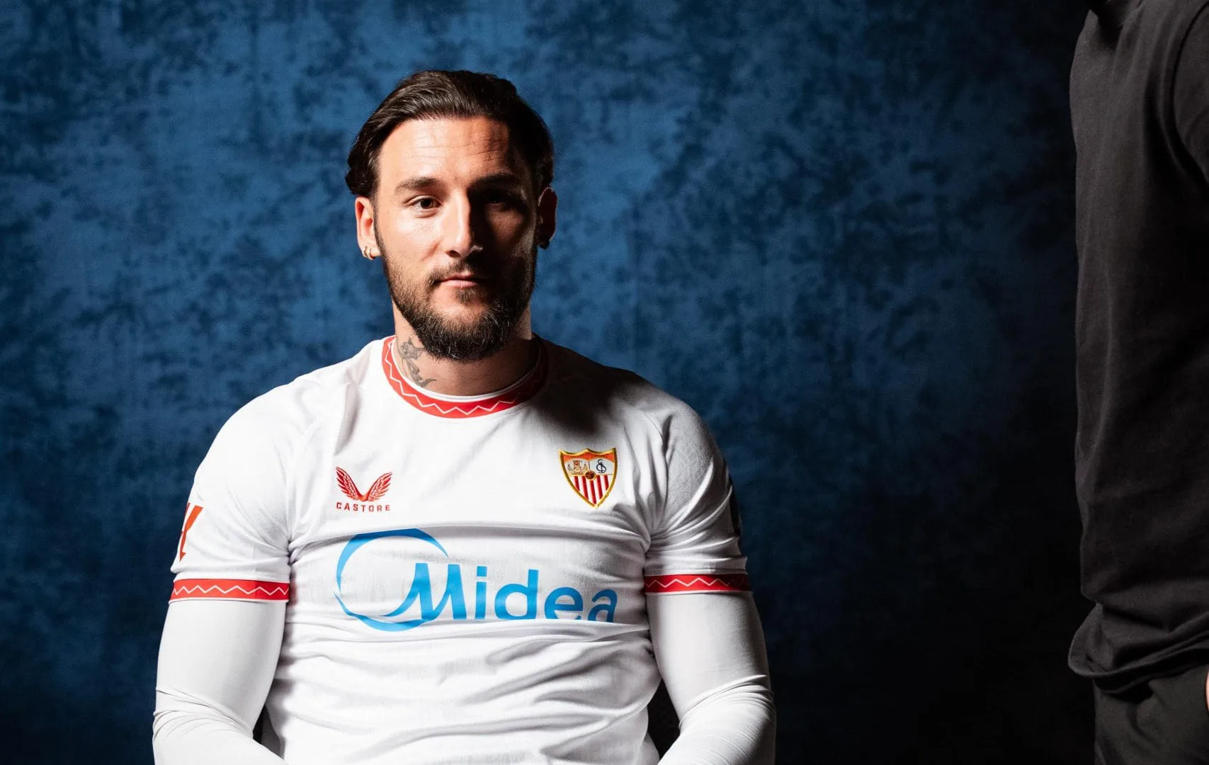 Congelados x Sevilla FC: Sevilla FC player seated for an interview as a crew member gives directions