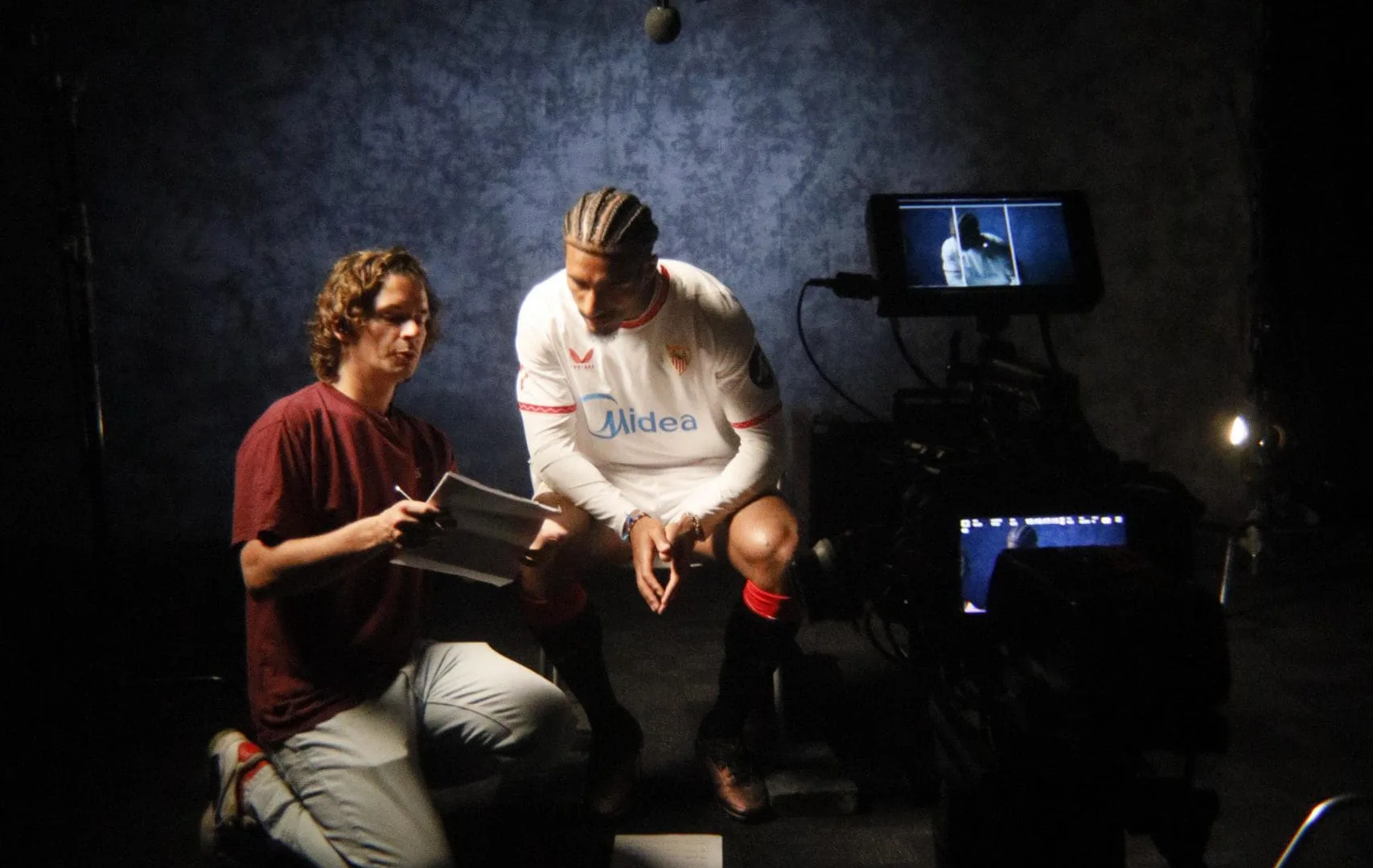 Congelados x Sevilla FC shoot: crew member going over notes with a Sevilla FC player on set