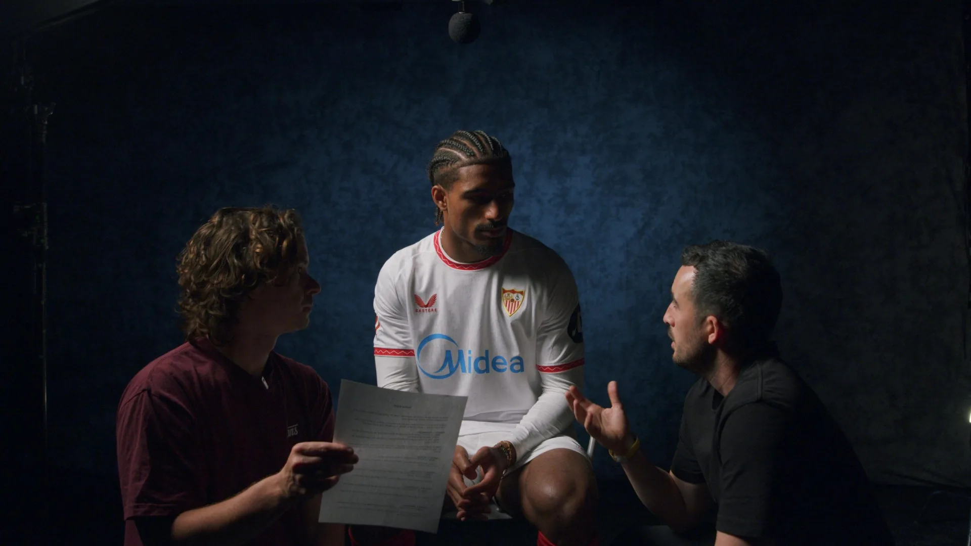 Congelados x Sevilla FC: two crew members briefing a Sevilla FC player before an interview