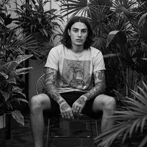 Digital Humans: black and white AI portrait of a tattooed man among plants