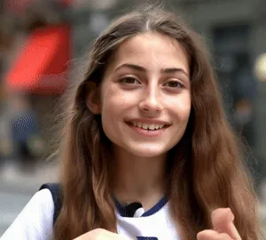 Digital Humans: AI-generated young woman smiling and talking to camera in the street