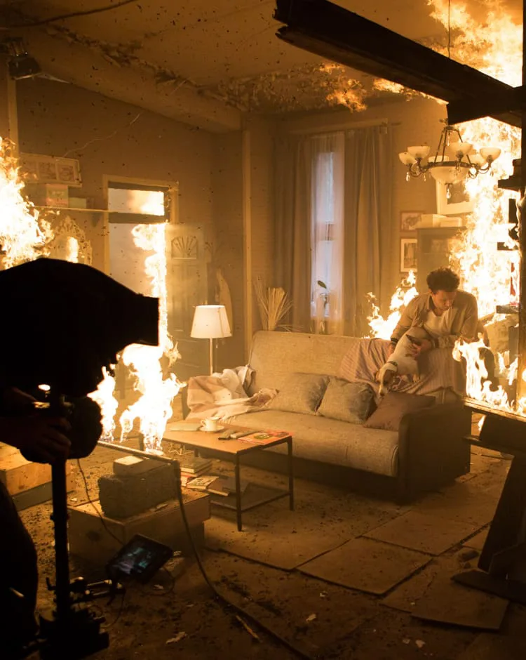 Behind the scenes of a commercial by Ene Fariña: an actor with a dog on a living-room set in flames
