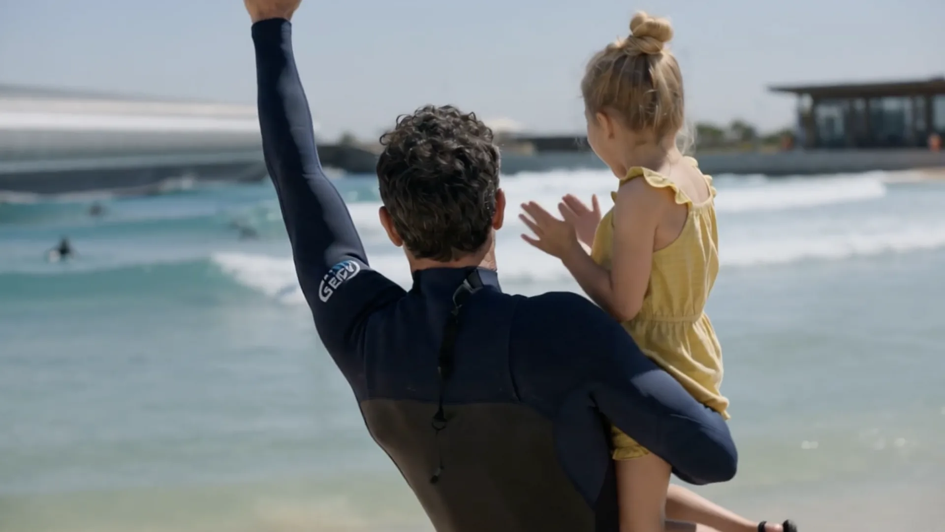 Gemswell Society, película con IA: un surfista con su hija en brazos junto a la laguna