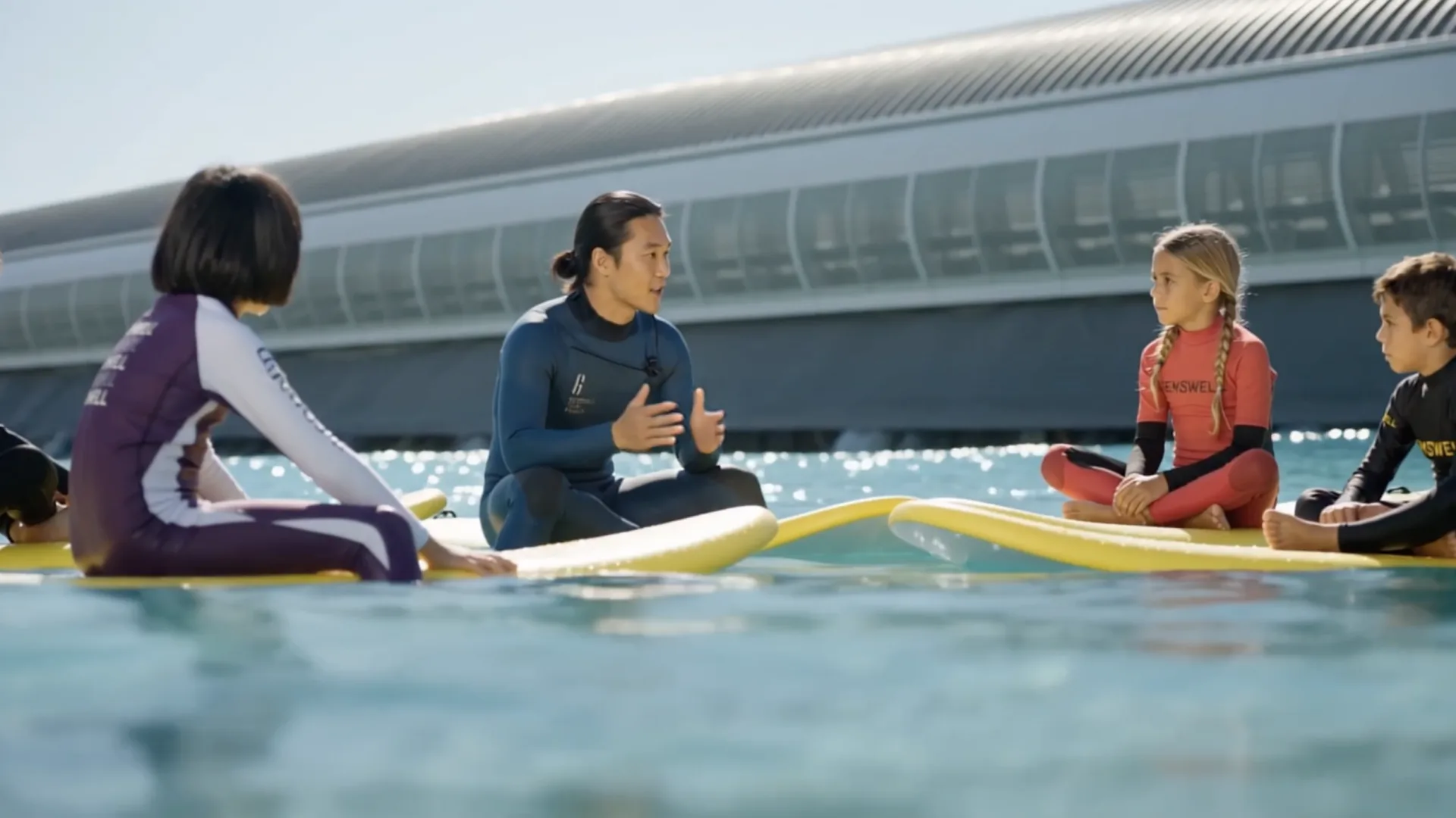 Gemswell Society, película con IA: un monitor da clase de surf a niños en la laguna