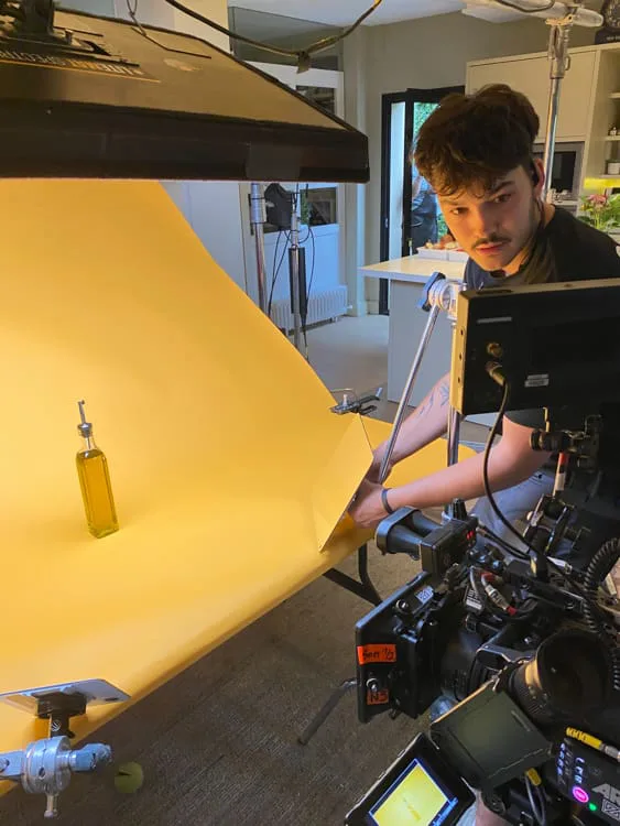Heinz Tomato Frito, behind the scenes: olive oil bottle lit on a yellow backdrop for a product shot