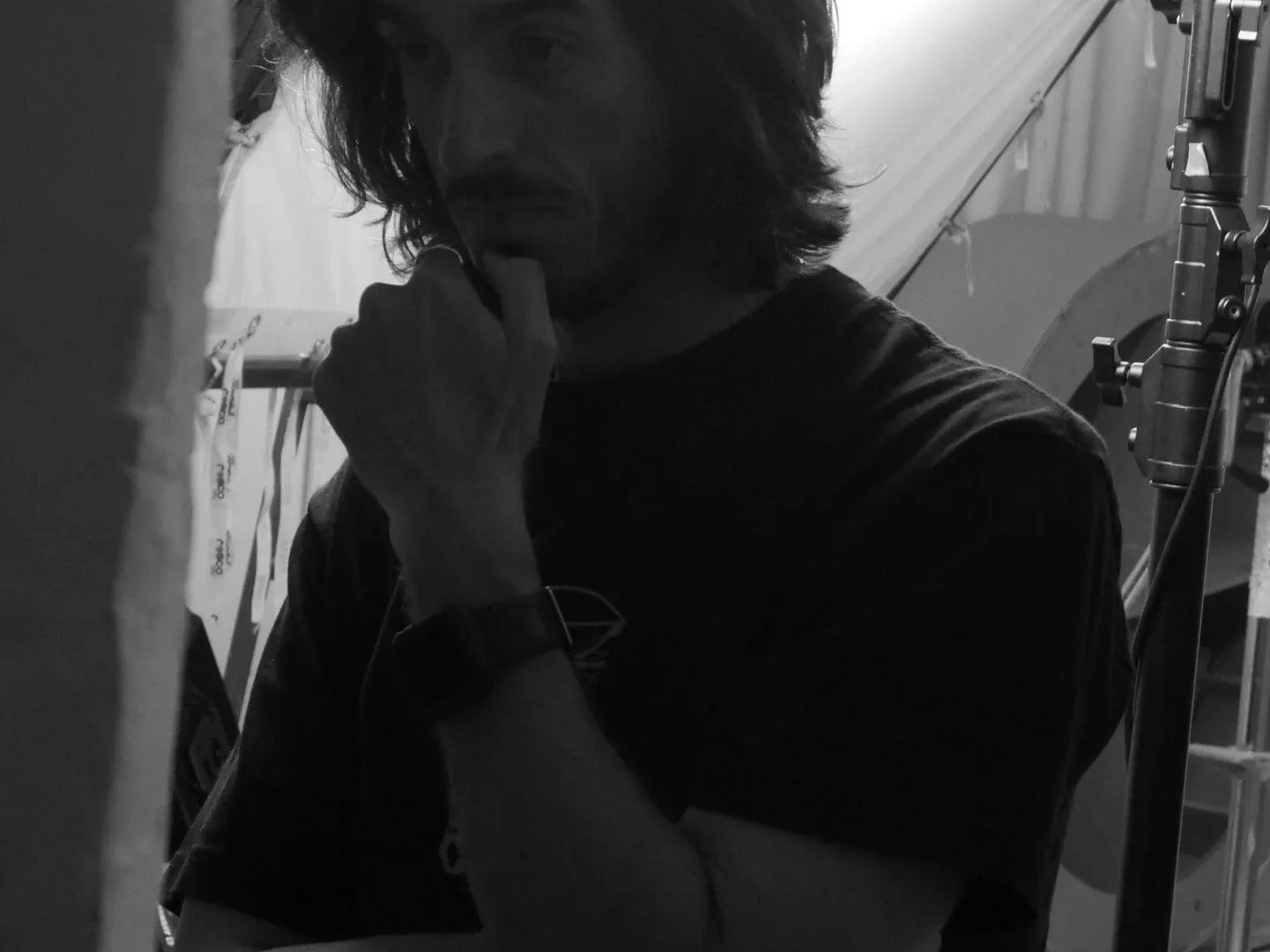 Making of de ISDIN Acniben: miembro del equipo pensativo en el set, en blanco y negro