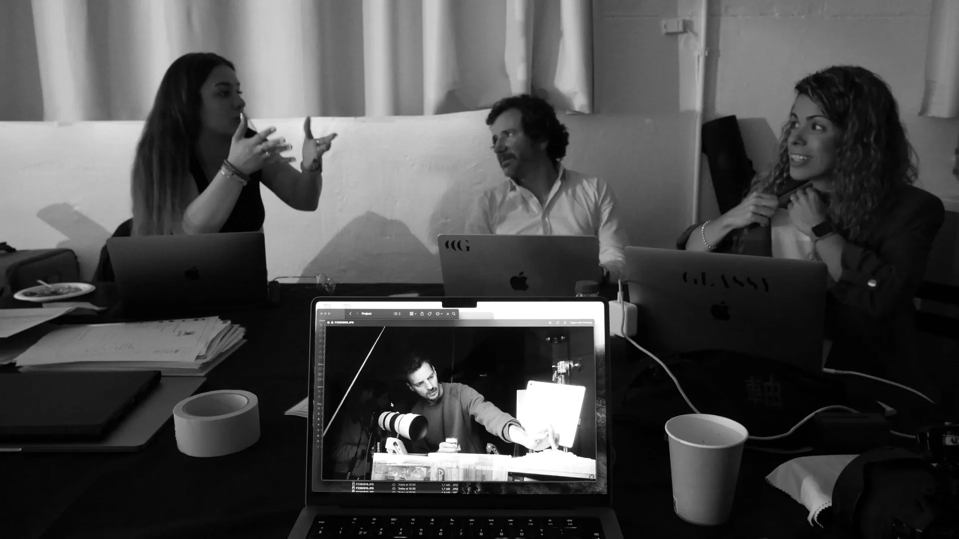 Isdin Hyaluronic making of: team discussing around laptops while a monitor shows the product unit