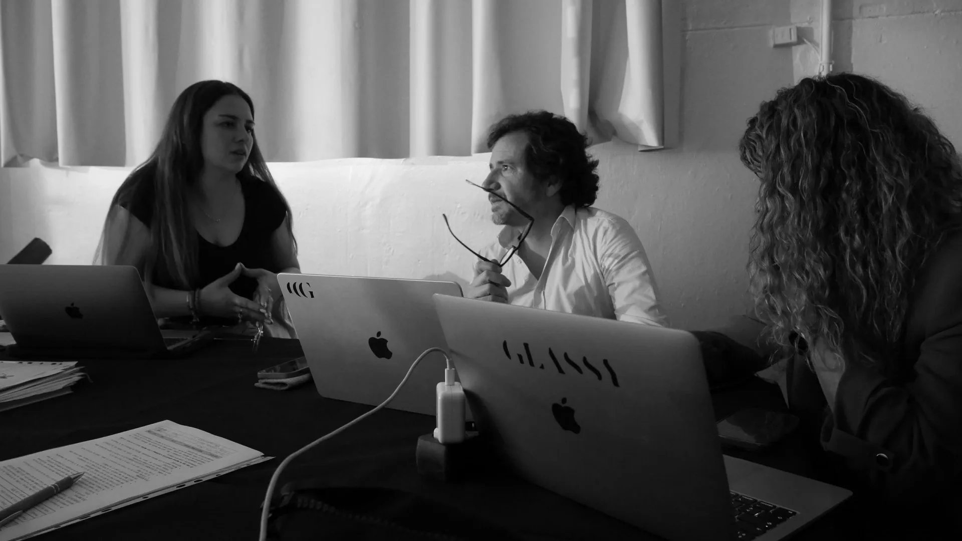 Isdin Hyaluronic making of: production team talking around Glassy laptops, black and white