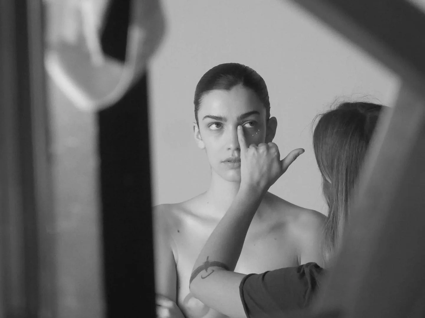 Isdin Ureadin shoot: makeup artist touching up a model's eye before a take