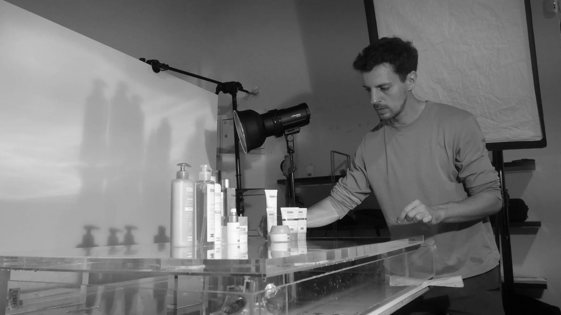 Isdin Ureadin shoot: crew member arranging Isdin bottles and tubes on an acrylic table