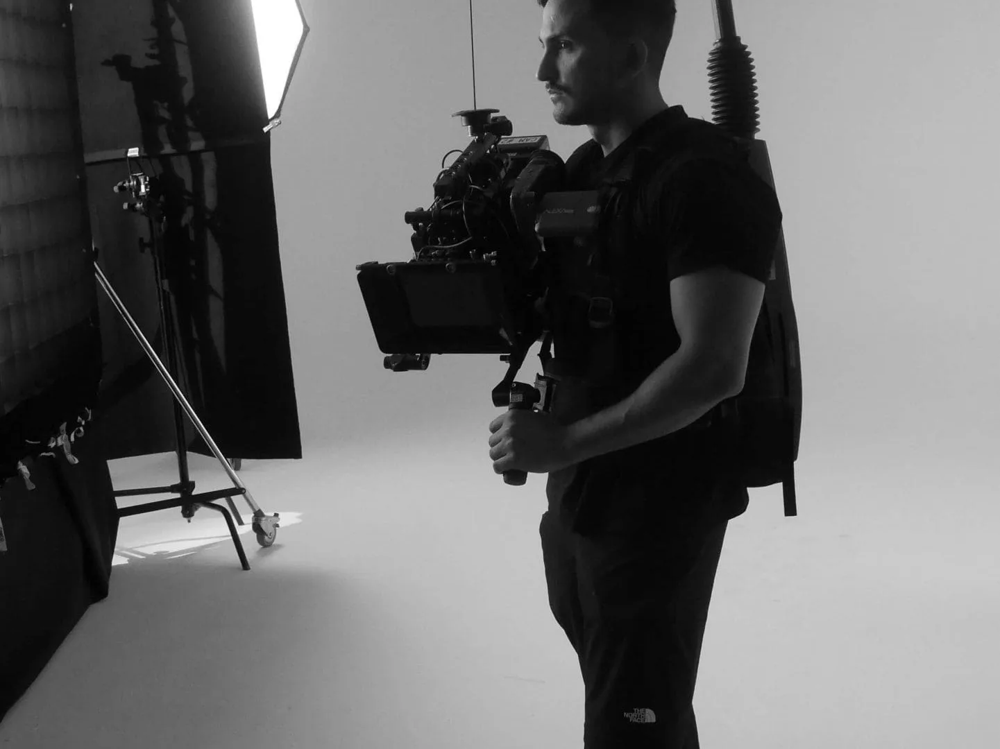Isdin Ureadin shoot: camera operator with a body-mounted camera rig waiting on the white set
