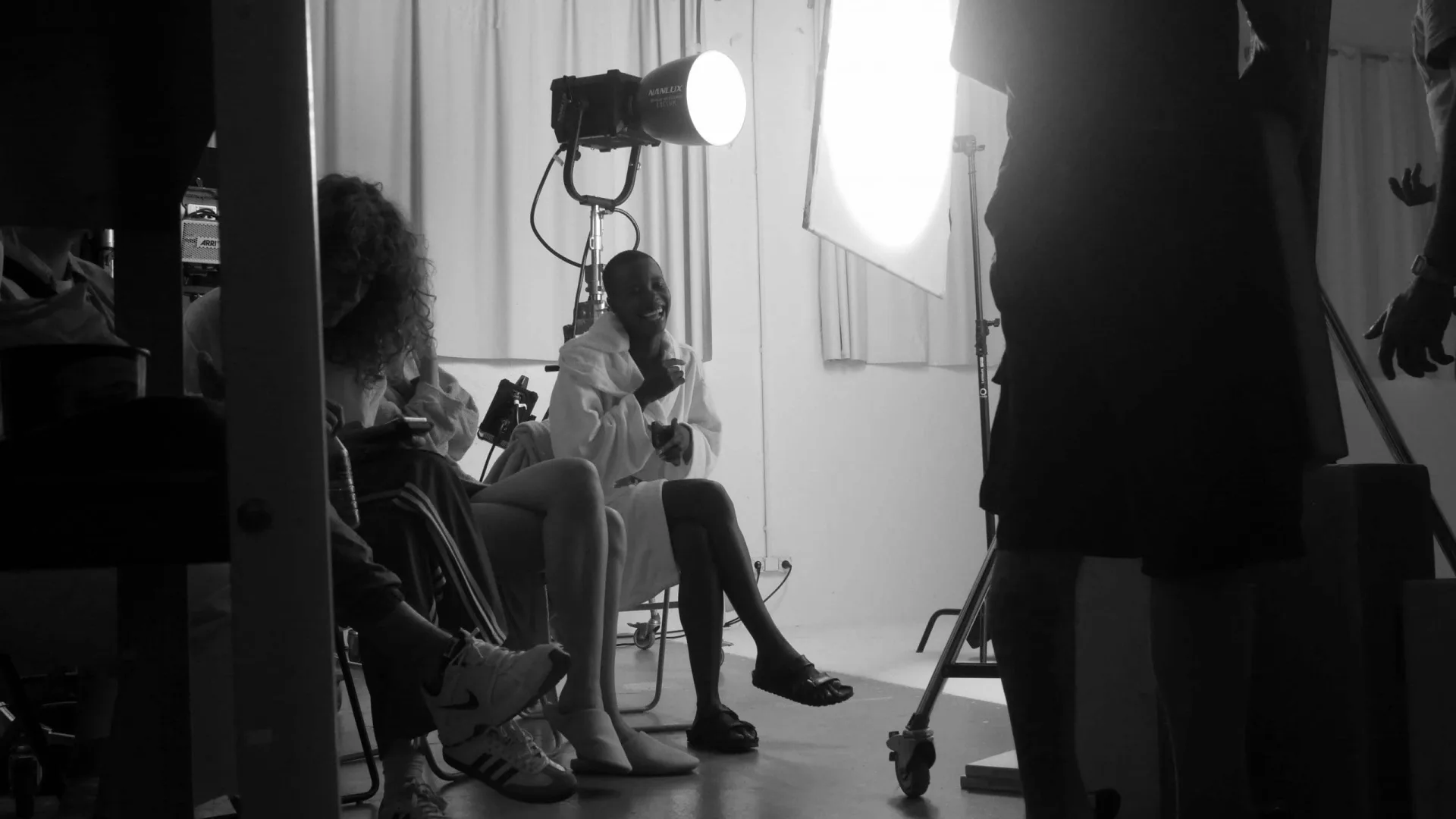 Isdin Ureadin shoot: a model rests in a robe between takes under the studio lights
