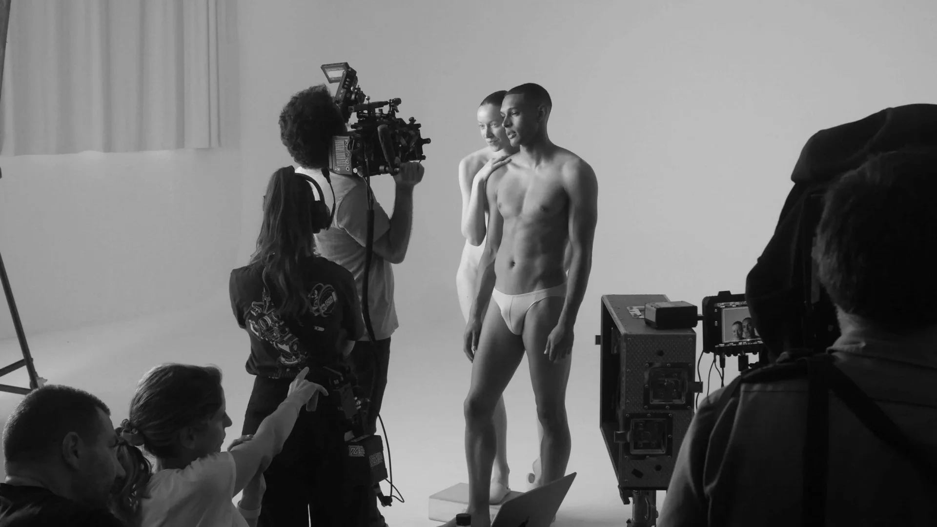 Isdin Ureadin shoot: camera crew filming two models in the white infinity studio