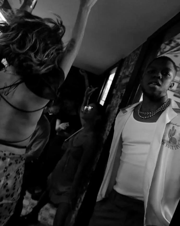 Black and white frame from a commercial by Jari: people dancing at a party