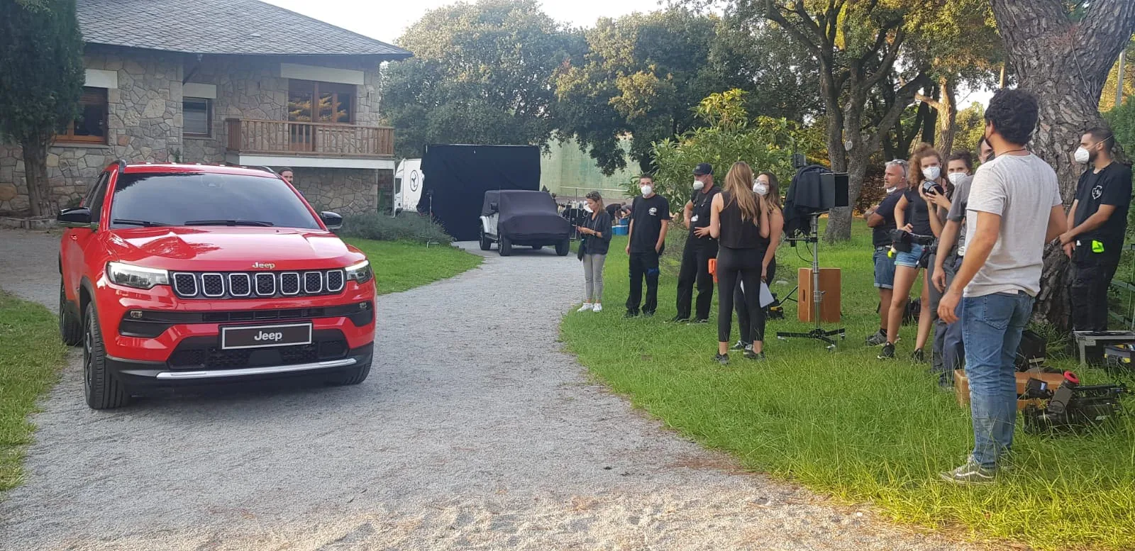 Jeep shoot: red Jeep Compass on a gravel drive with the crew beside it