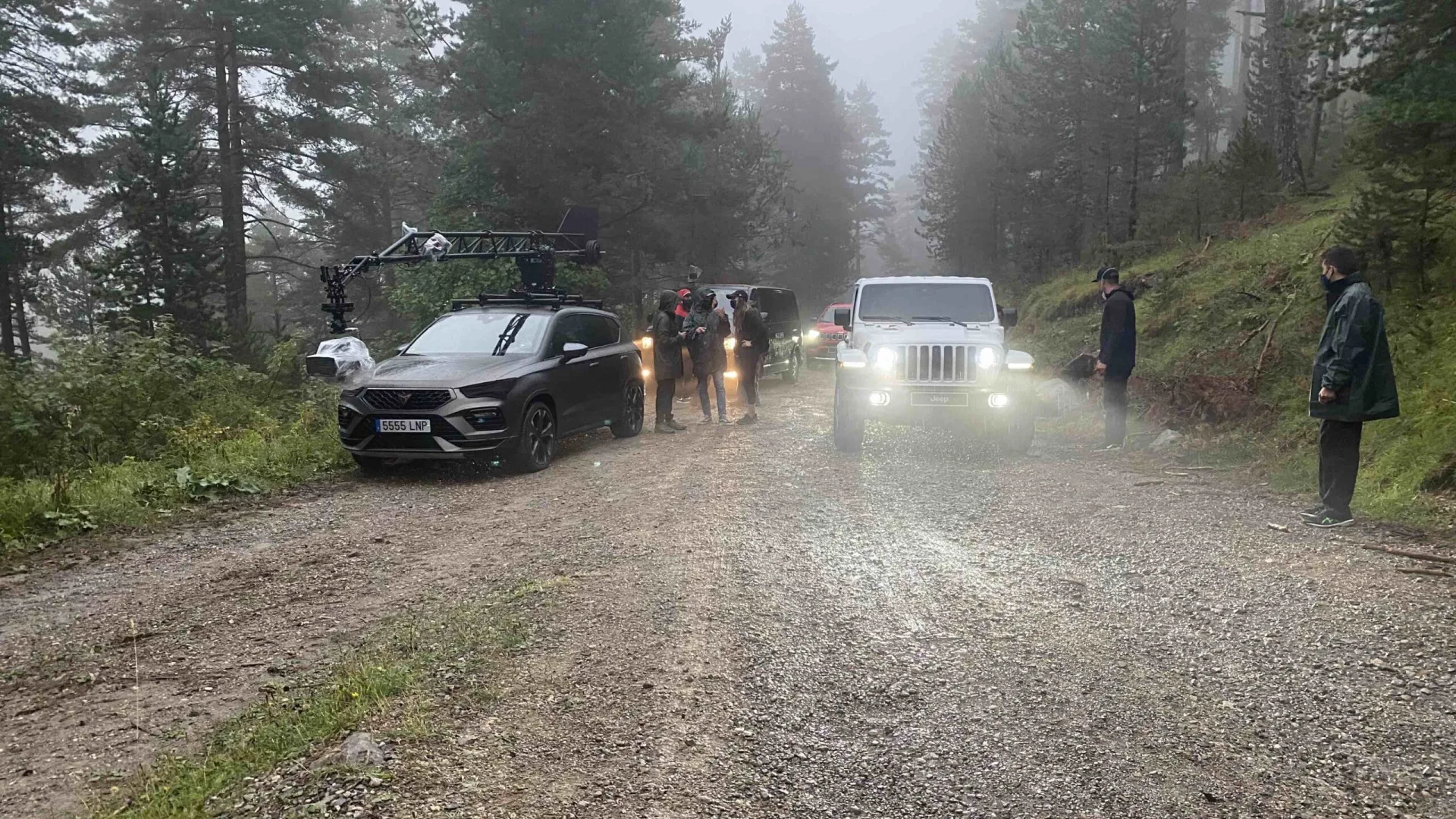 Jeep shoot: camera car and white Jeep Wrangler on a misty forest track