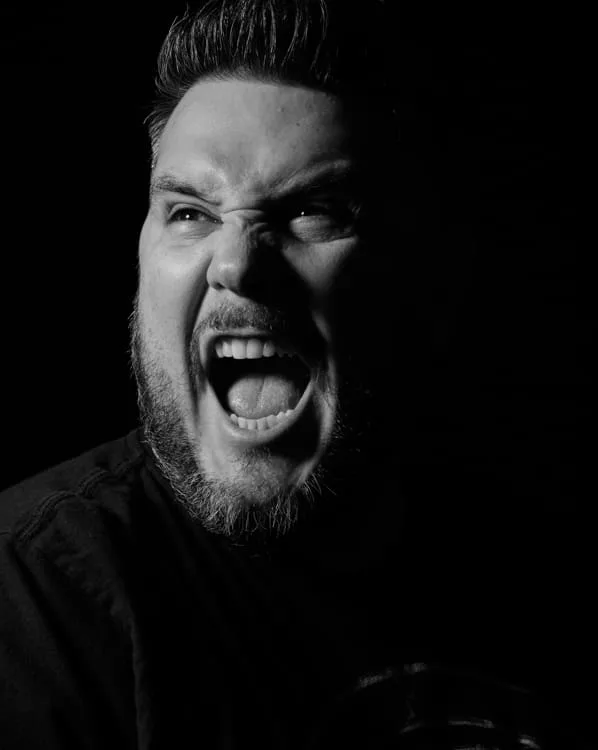 Retrato en blanco y negro de un hombre con barba gritando, del trabajo de Mike Palafox