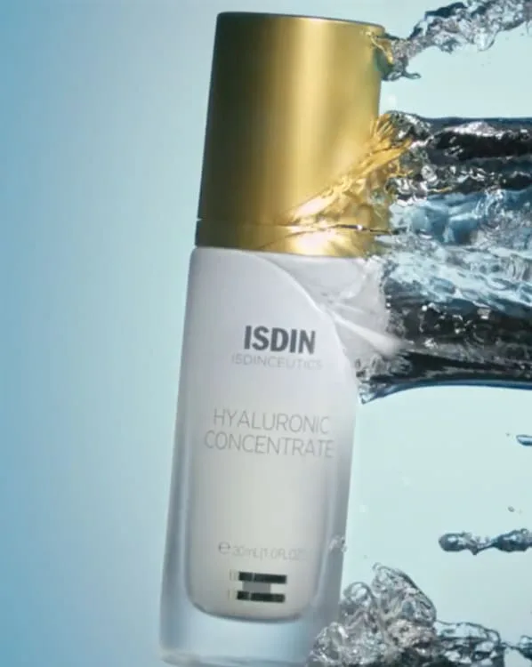 Frasco de ISDIN Hyaluronic Concentrate salpicado de agua, de un anuncio de Mike Palafox