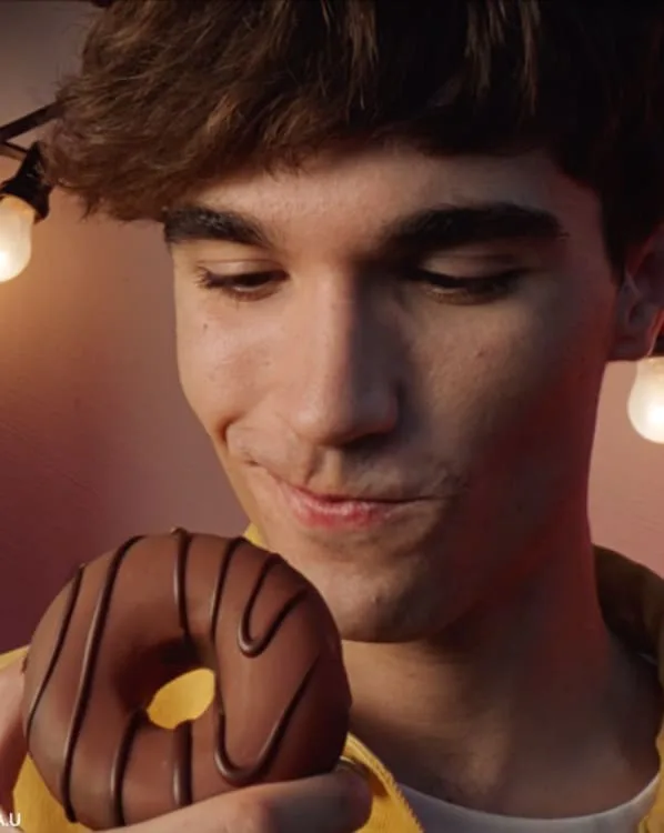 Chico a punto de comer un dónut de chocolate, de un anuncio de Mike Palafox