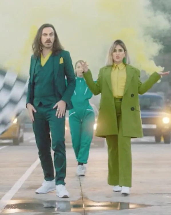 Frame from a commercial by Pedro Abreu: performers in green suits walking through yellow smoke