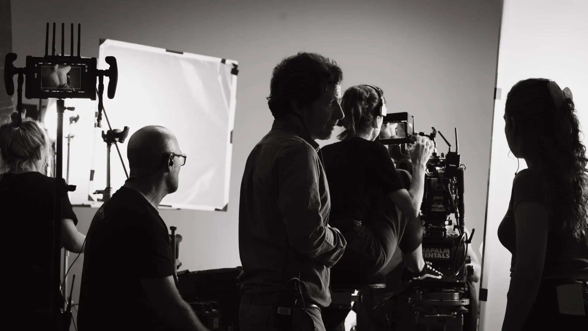 Sanex UAP shoot: crew in silhouette around the camera in front of a lighting frame, black and white