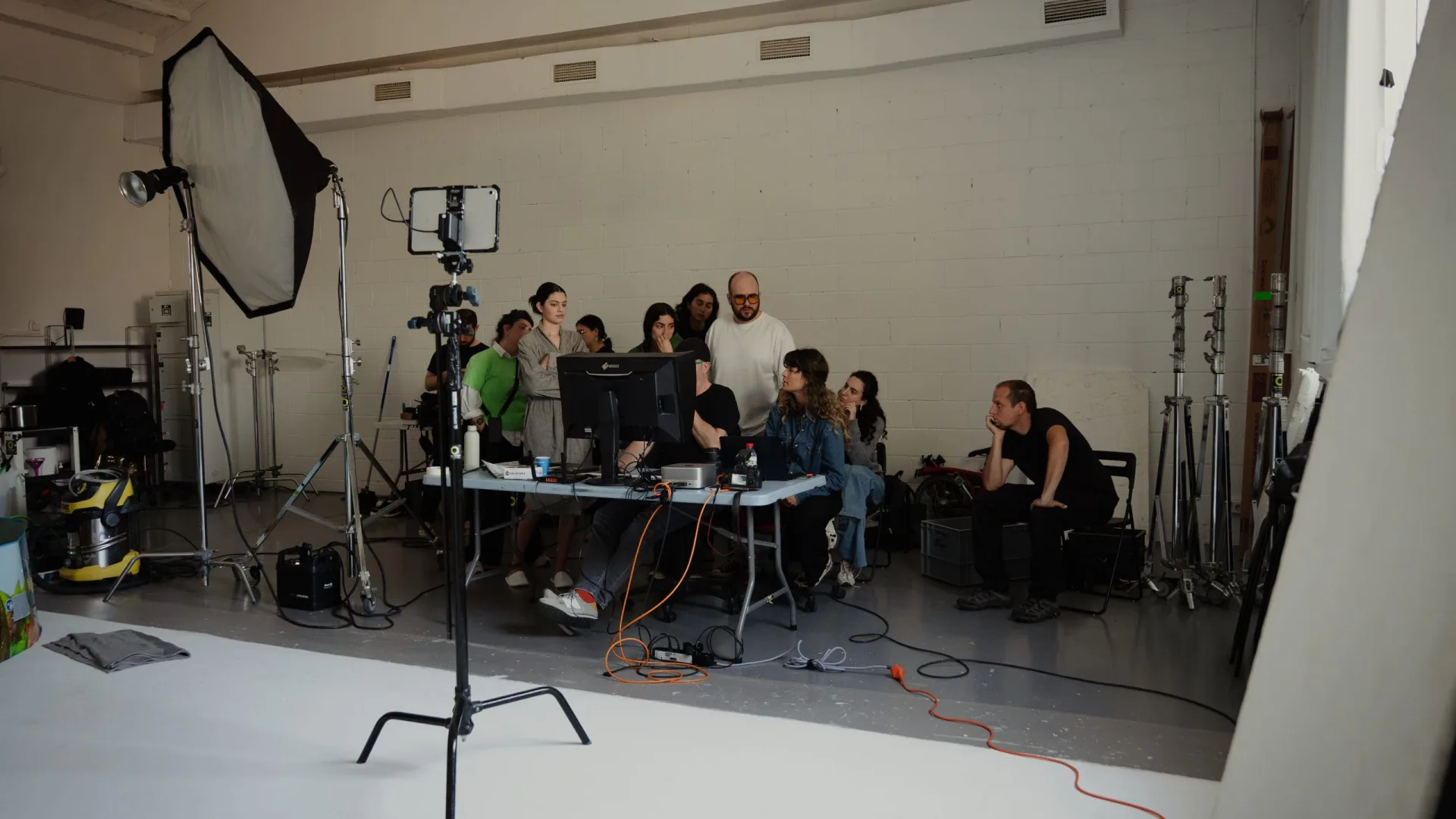 Sanex UAP shoot: team reviewing takes around a monitor table in a white studio