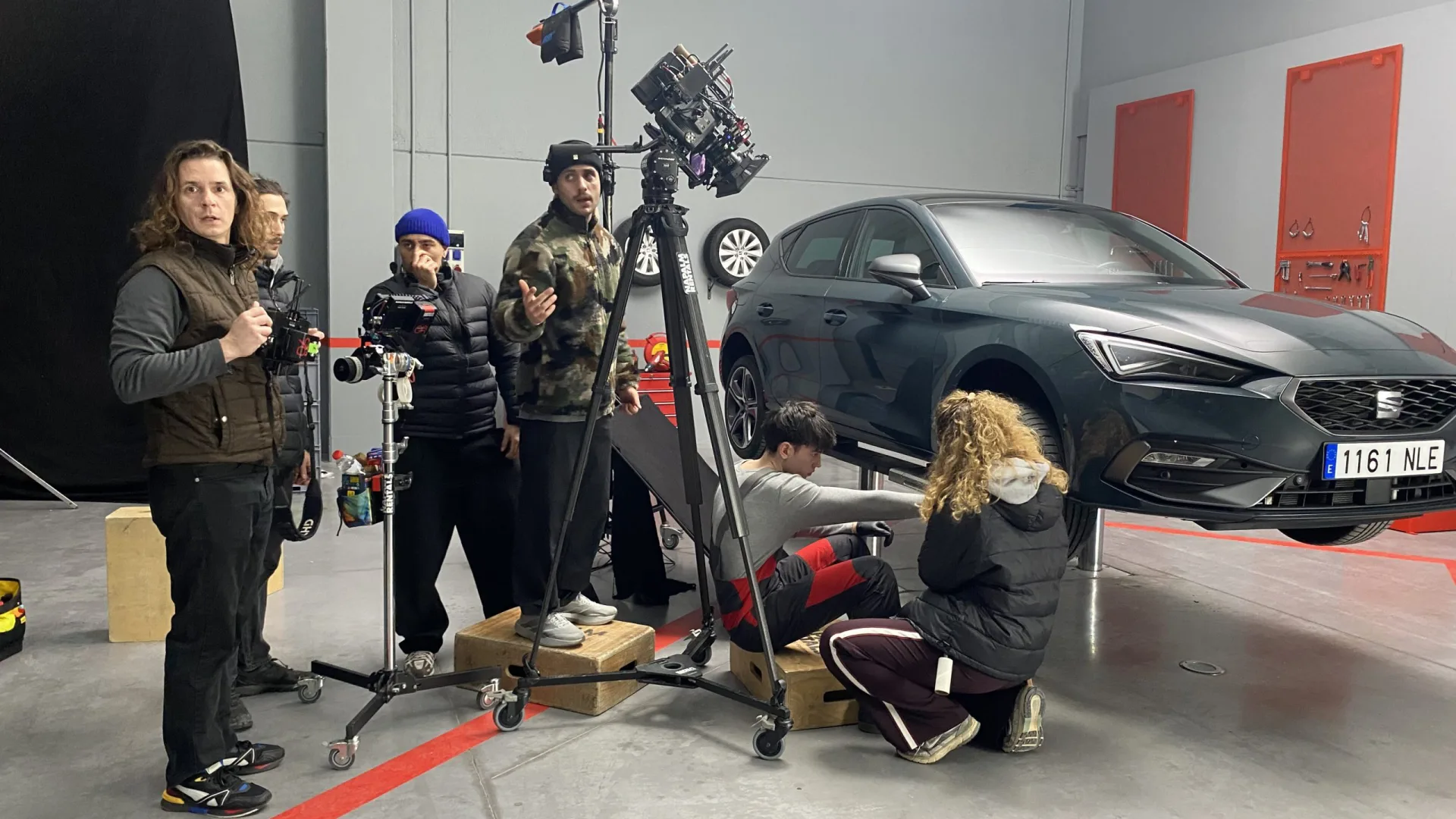 Seat Connect shoot: crew filming actors working under a Seat León in the workshop set