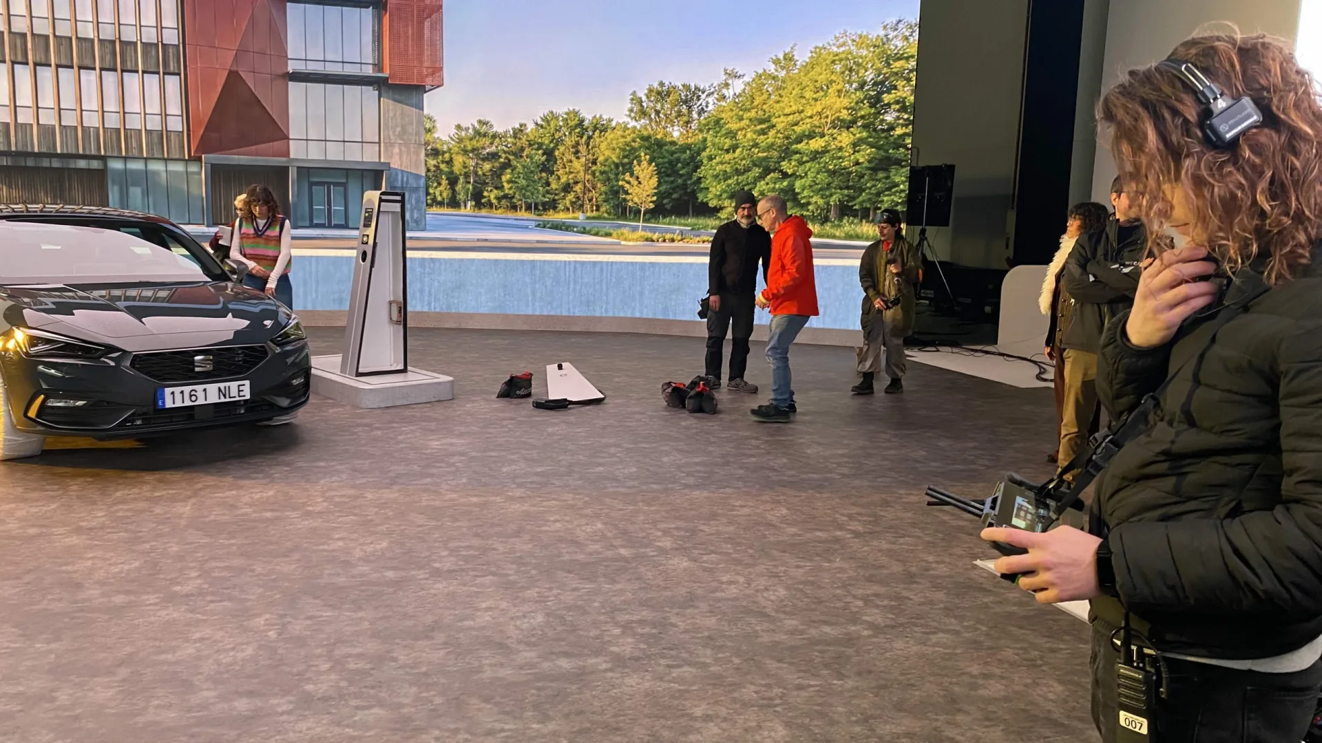 Seat Connect making of: crew on the LED stage beside a Seat León and a charging point