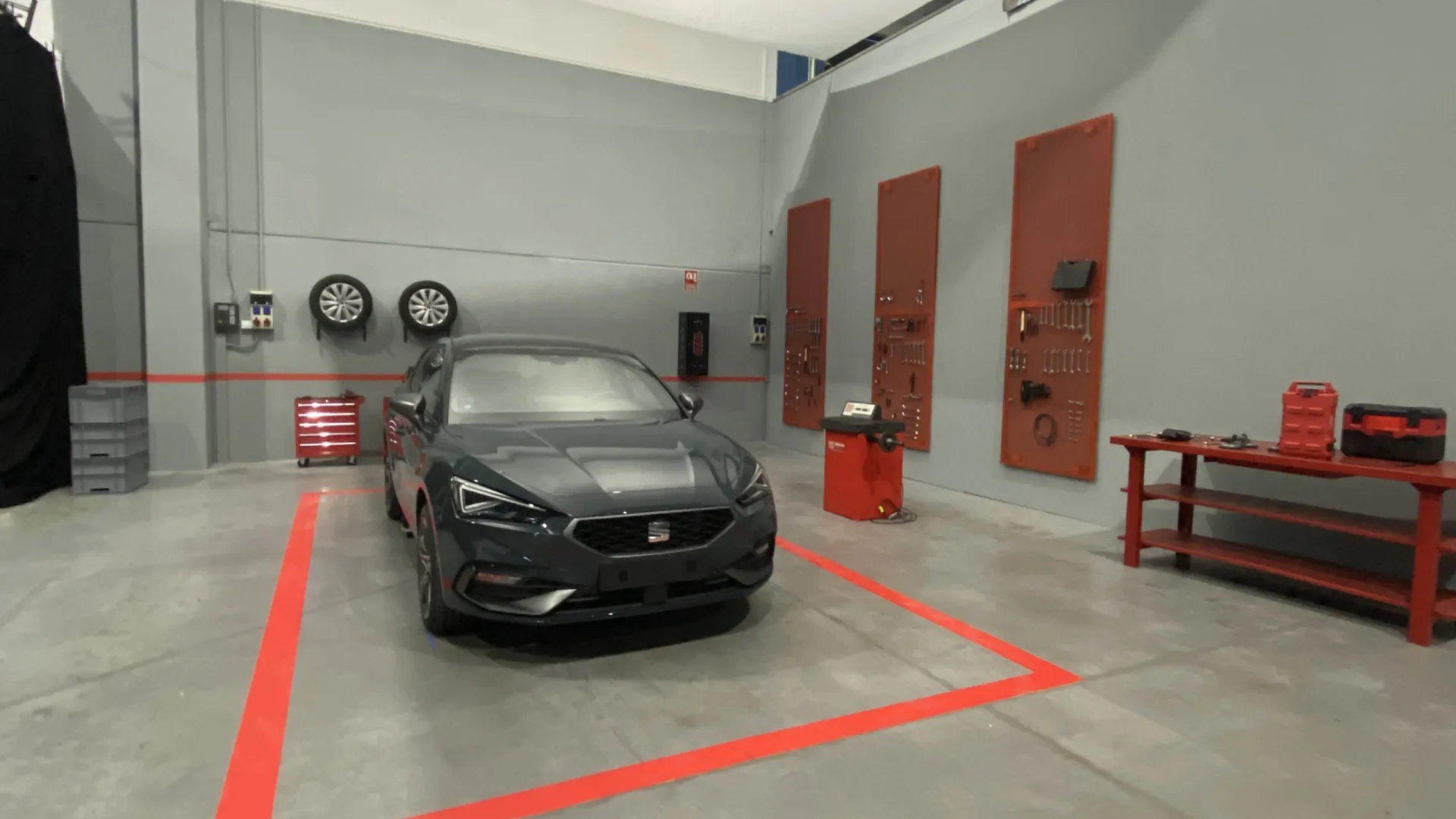 Seat Connect set: Seat León parked in a grey and red workshop built in the studio