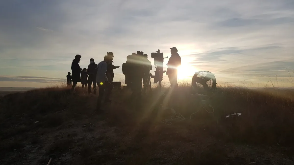 El equipo de rodaje de Glassy Films a contraluz en lo alto de una colina al amanecer, en un rodaje en exteriores