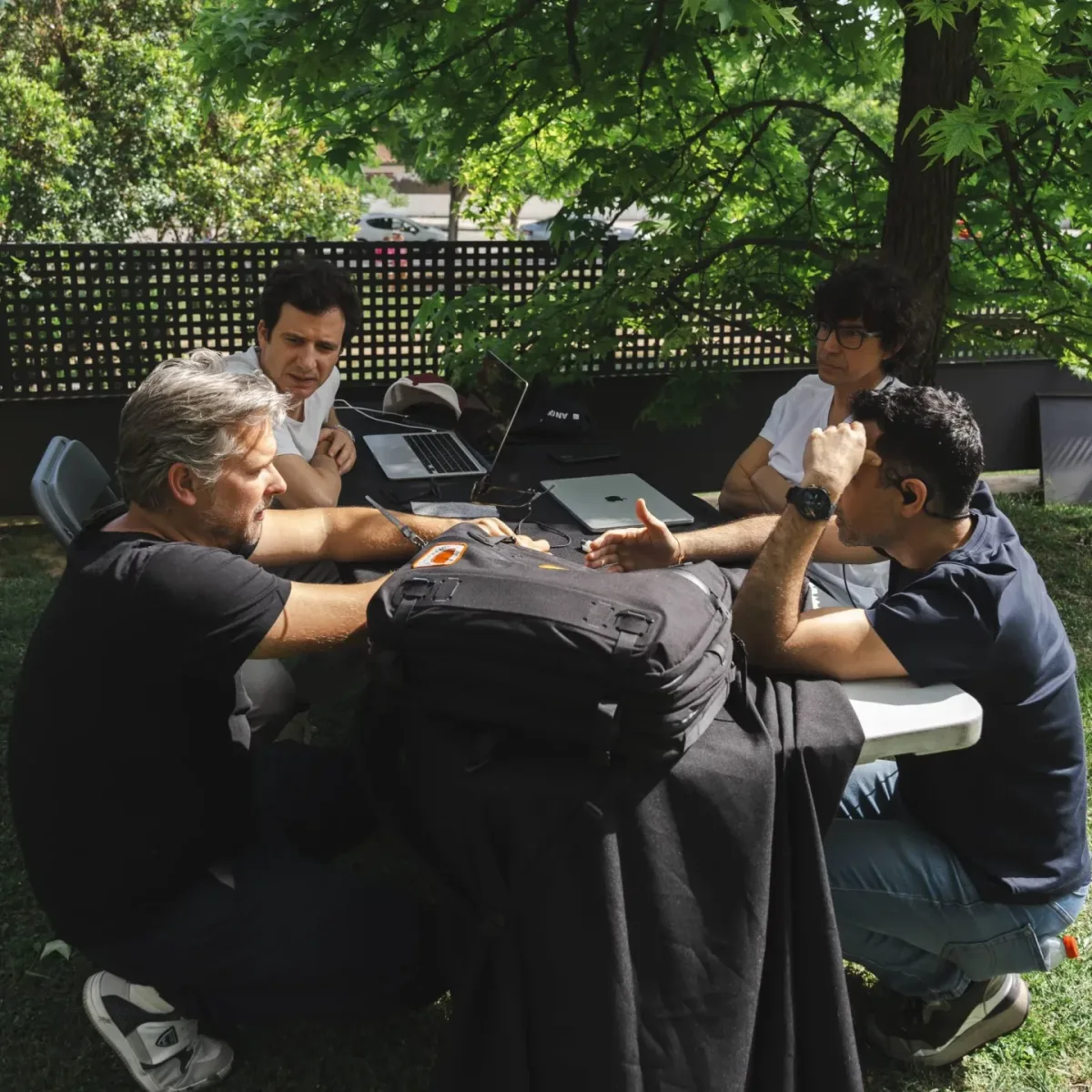 El equipo de Glassy Films en una reunión de producción, en una mesa del jardín