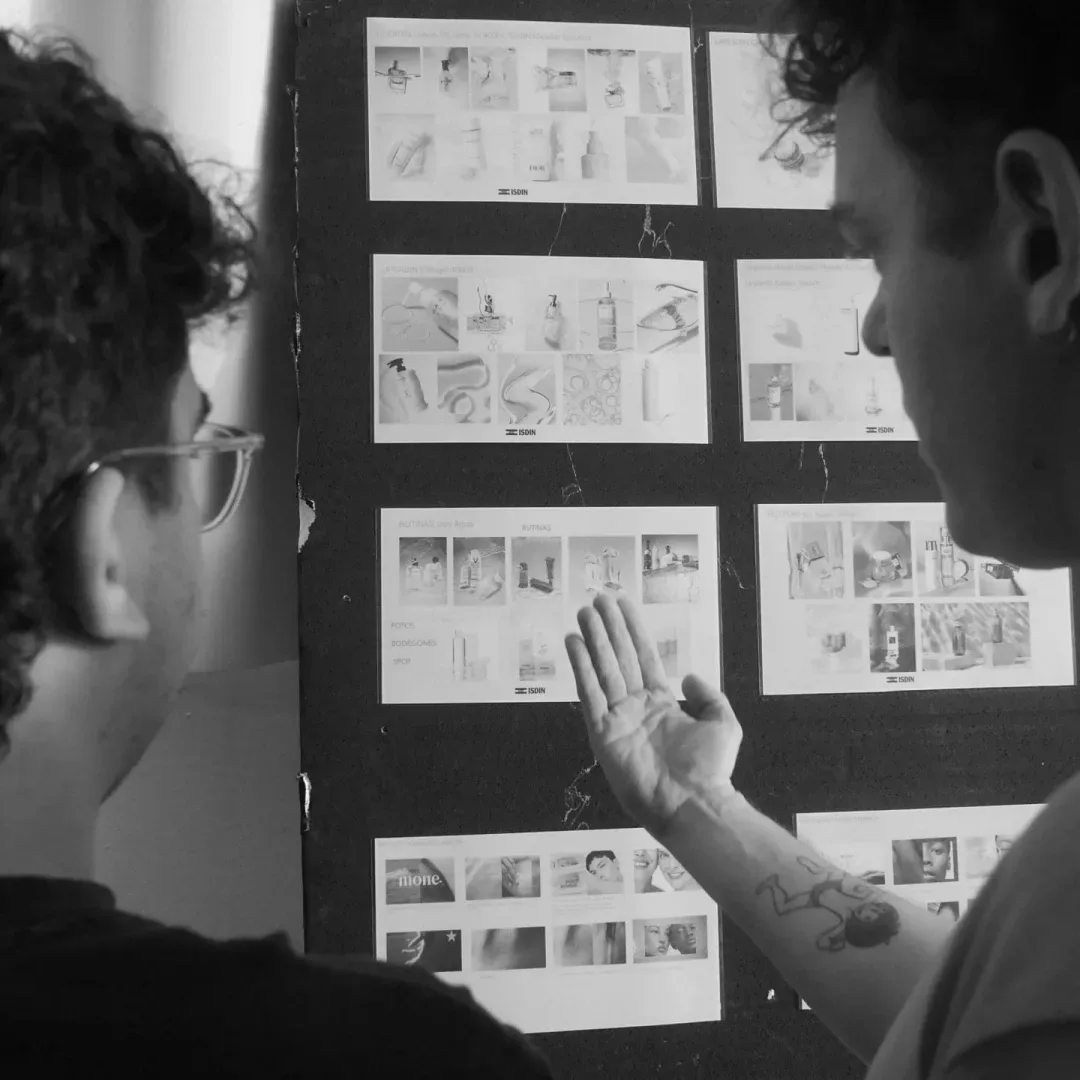 ISDIN Ureadin, making of: dos miembros del equipo señalan el storyboard, en blanco y negro