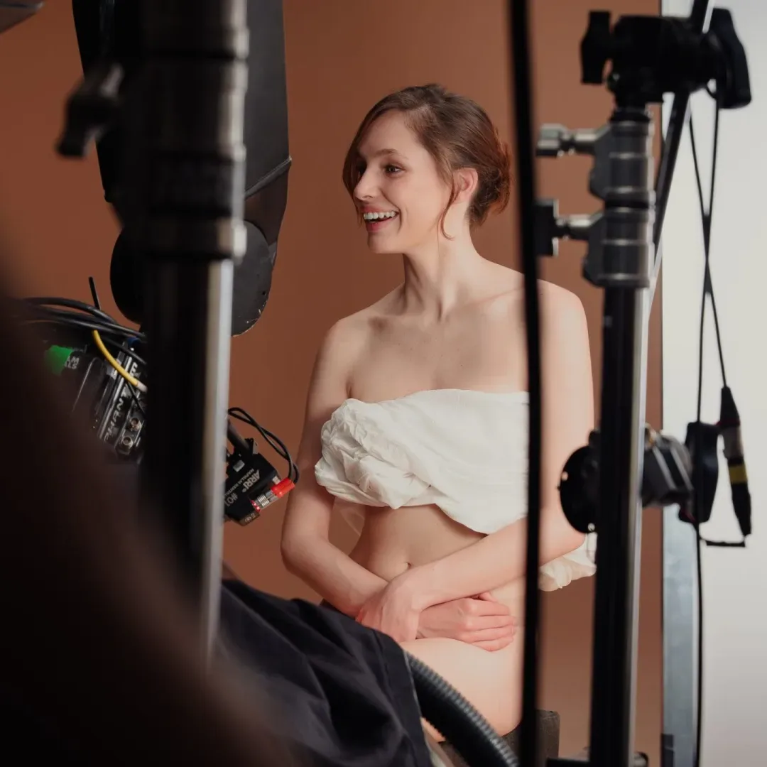 Sanex UAP, making of: una modelo sonriente envuelta en una tela blanca en el plató