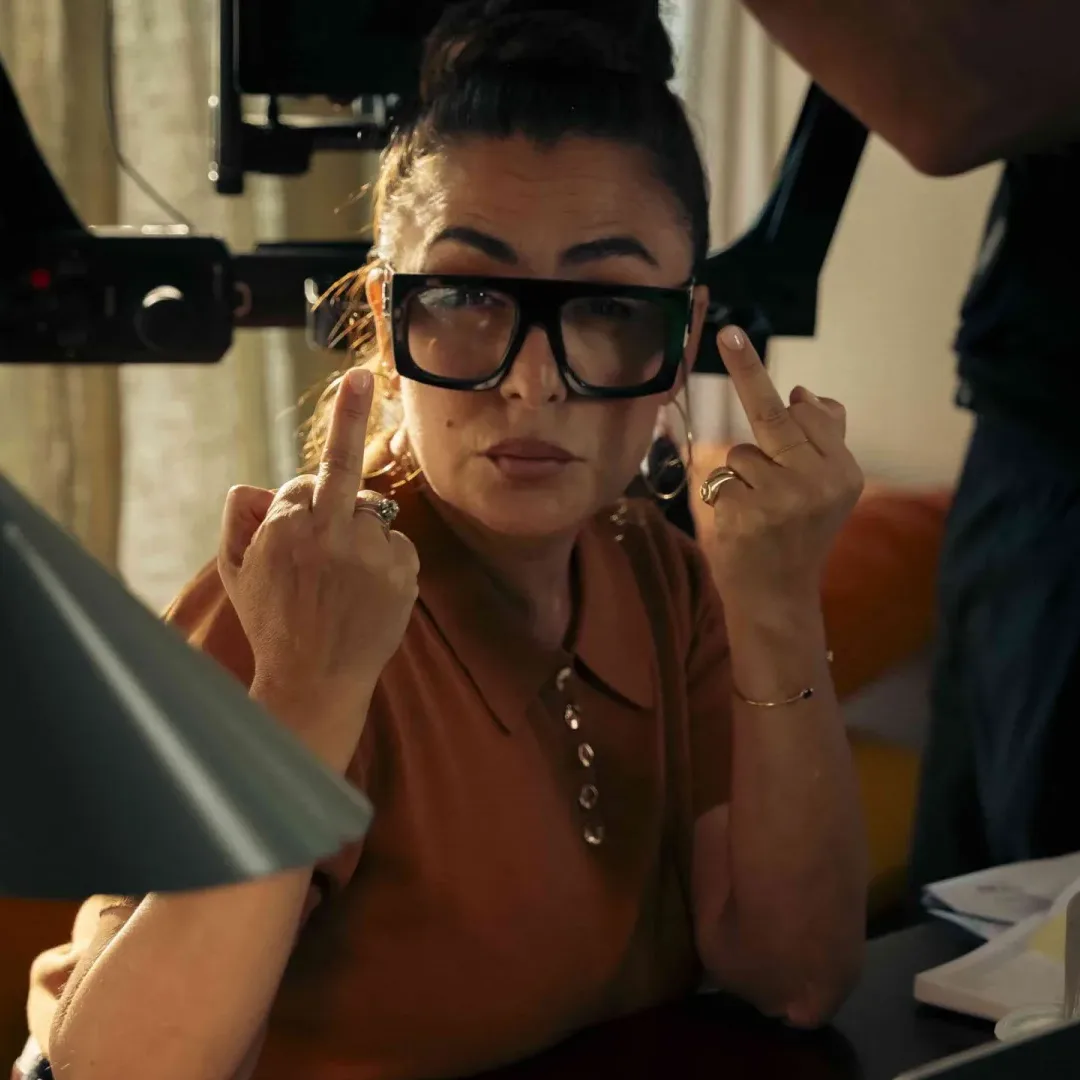 Activia, making of: una mujer con gafas grandes hace una peineta a la cámara, en broma, en el set
