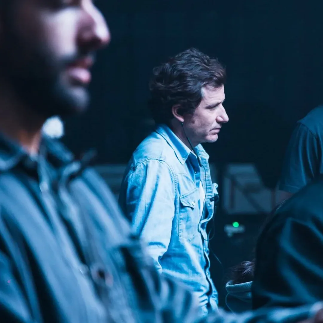 Dos miembros del equipo de Glassy Films siguen una toma en un set iluminado en azul