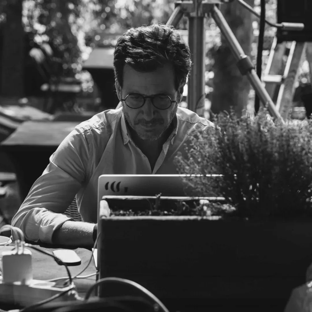 Activia, making of: un miembro del equipo trabaja con el portátil al aire libre, en blanco y negro