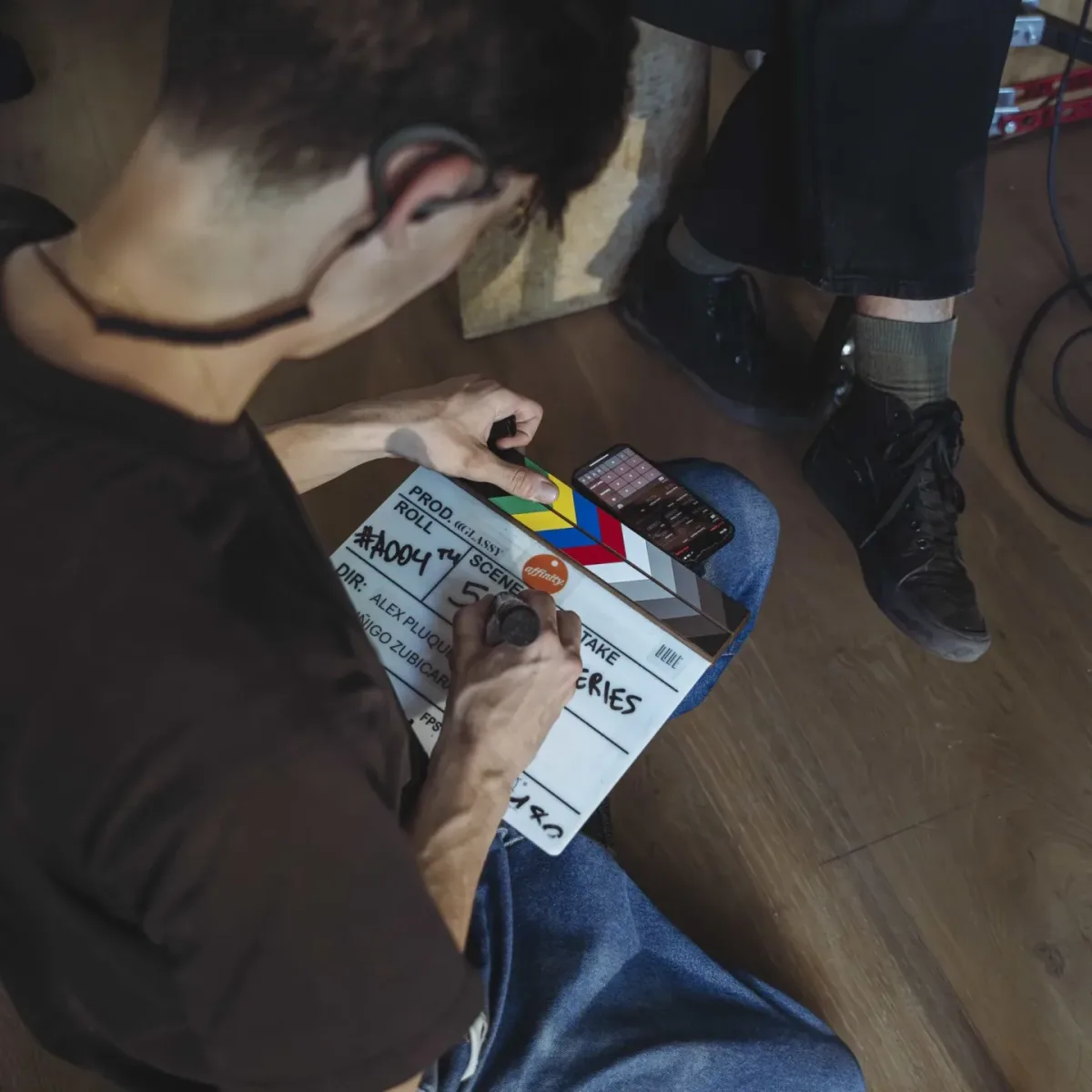 Vista cenital de un miembro del equipo de Glassy Films rellenando la claqueta